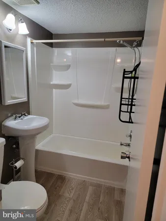 a bathroom with a sink a toilet a mirror and shower