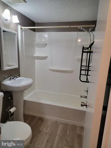 a bathroom with a sink a toilet a mirror and shower