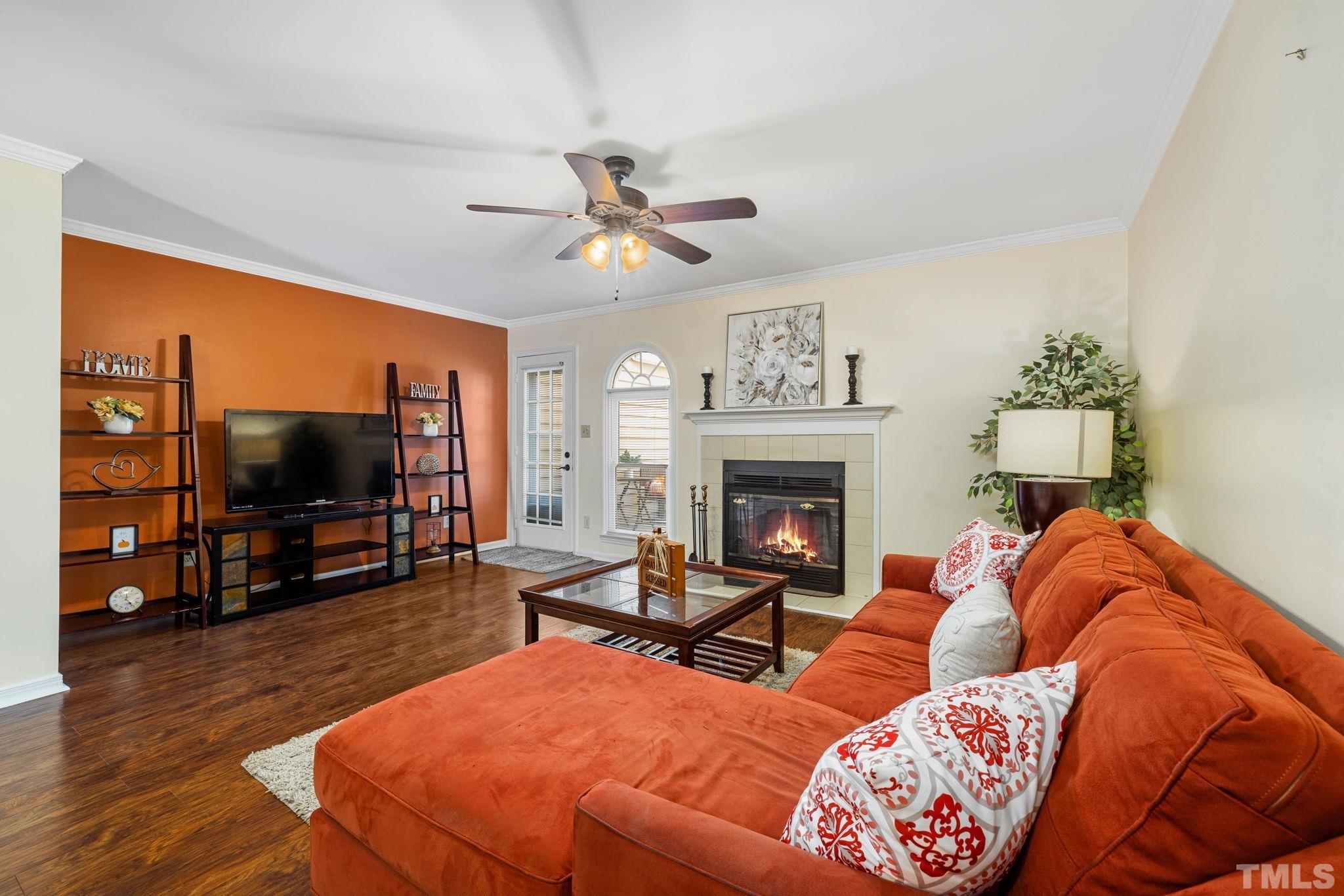 4544 Antique Lane Raleigh, NC 27616 - Photo 5 of 20 a living room with furniture a flat screen tv and a fireplace