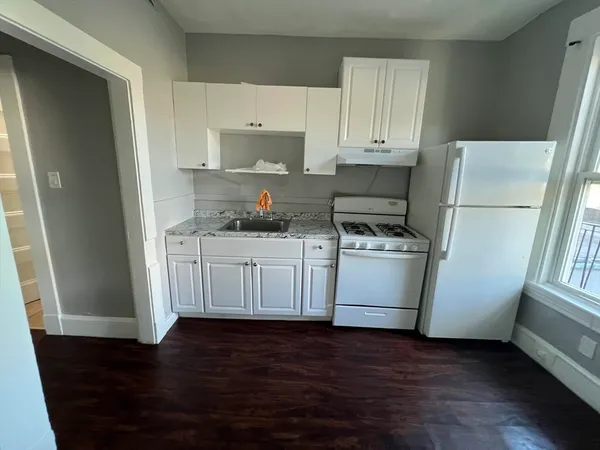 a kitchen with white cabinets and white appliances