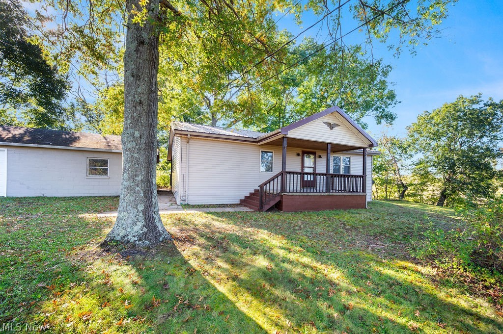 58 Rock Ridge Road Mineral Wells, WV 26150 - Photo 20 of 38 Covered front porch with railing, exterior siding, and an attached garage