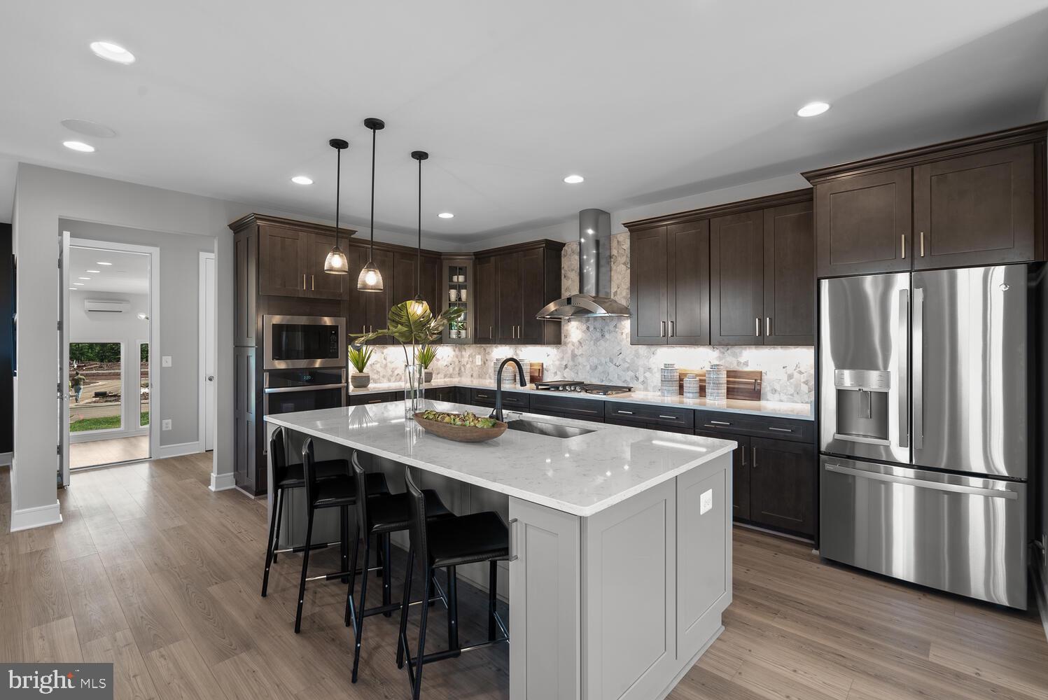 22873 Aurora Vw Drive Brambleton, VA 20148 - Photo 1 of 31 a kitchen with stainless steel appliances a table chairs refrigerator and wooden floor
