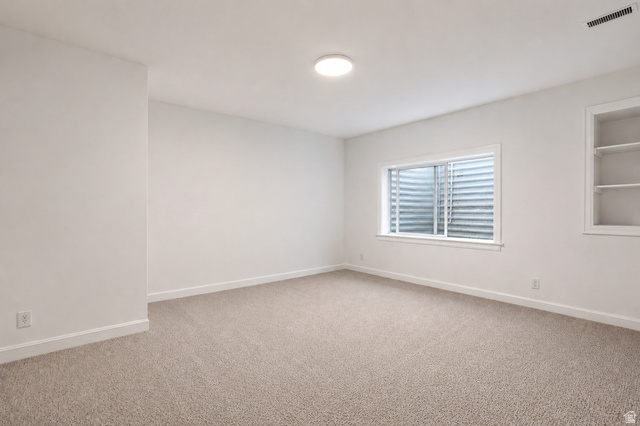 1429 Chateau Ridge Way Sandy, UT 84092 - Photo 17 of 22 Carpeted room featuring a white interior, egress window, built-in shelving, white baseboards, and a flush-mount ceiling light fixture