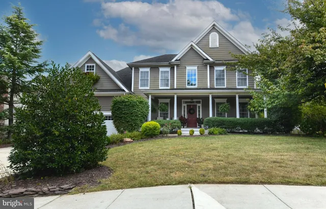 a front view of a house with a yard and trees