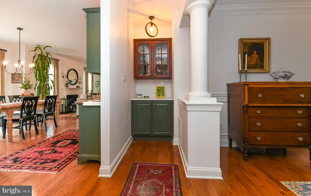 a walk in closet with wooden floor