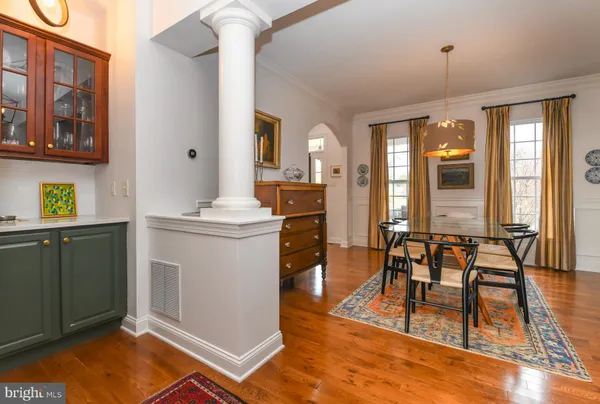 a view of a dining room with furniture a chandelier and wooden floor