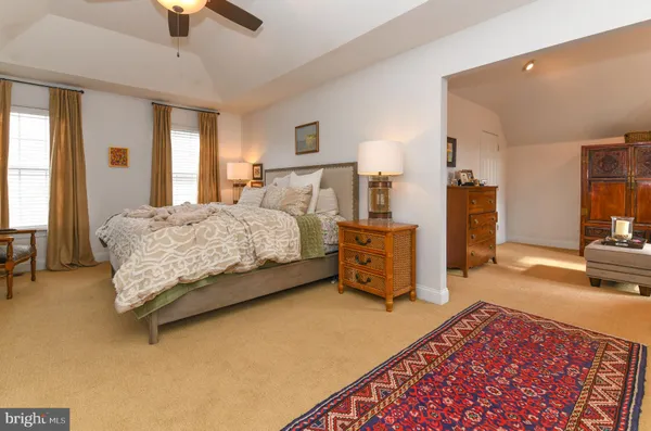 a bedroom with a bed a couch and a chandelier