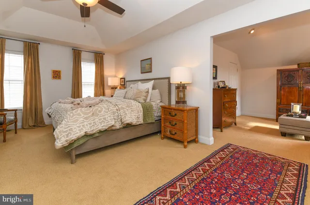 a bedroom with a bed a couch and a chandelier