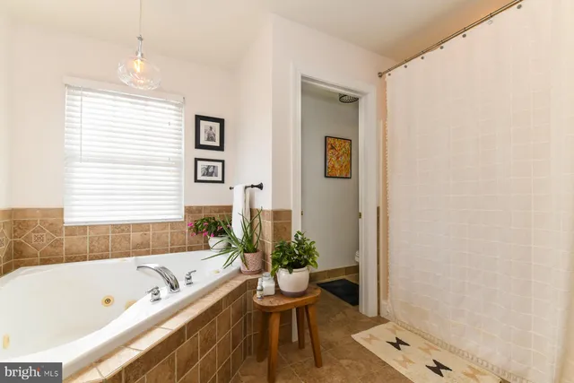 a bathroom with a tub sink and mirror