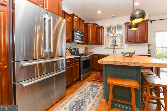 a kitchen with stainless steel appliances granite countertop a sink and a refrigerator