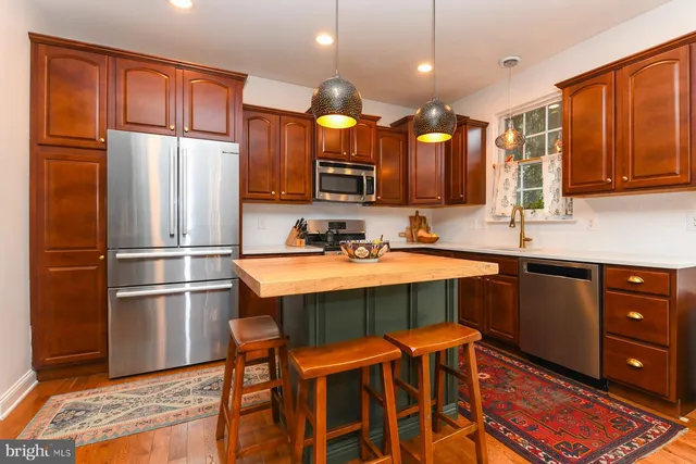 a kitchen with stainless steel appliances granite countertop wooden cabinets and a refrigerator