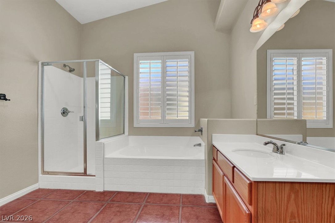 7308 Rustic Meadow Street Las Vegas, NV 89131 - Photo 19 of 27 Functional bathroom offering both a walk-in shower and a spacious bathtub, complemented by a vanity with a large mirror.