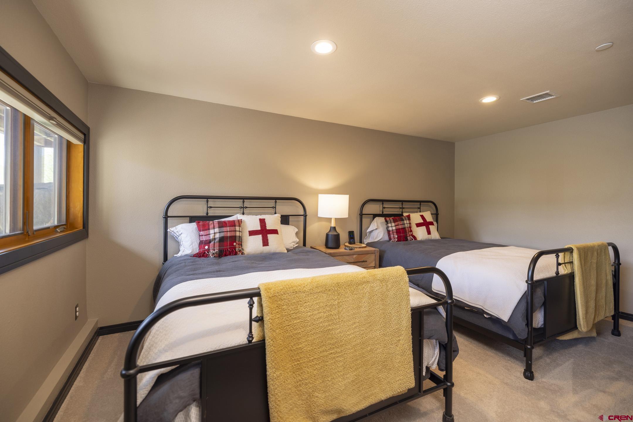 154 Falcon Ridge Road Durango, CO 81301 - Photo 31 of 42 a bedroom with a bed and a chandelier