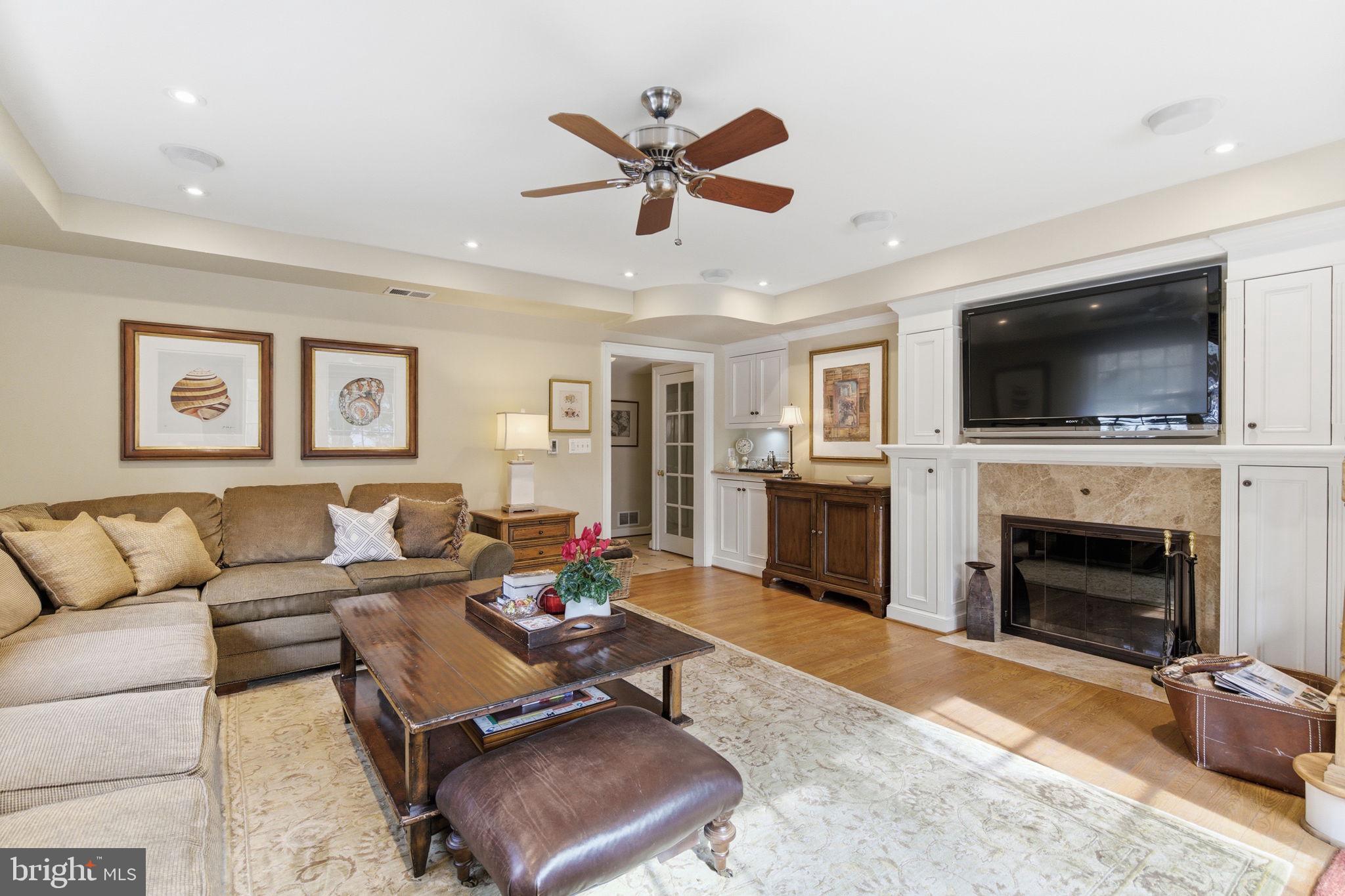 5310 Elliott Road Bethesda, MD 20816 - Photo 35 of 89 a living room with furniture a fireplace and a flat screen tv