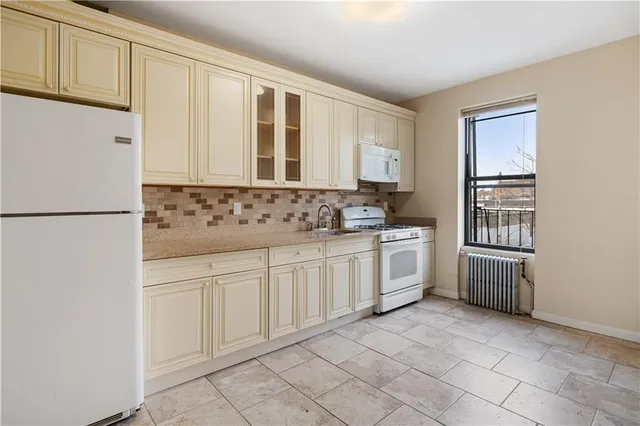 a kitchen with white cabinets and white appliances