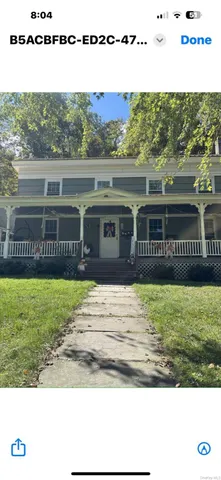 a living room with furniture a flat screen tv and a floor to ceiling window