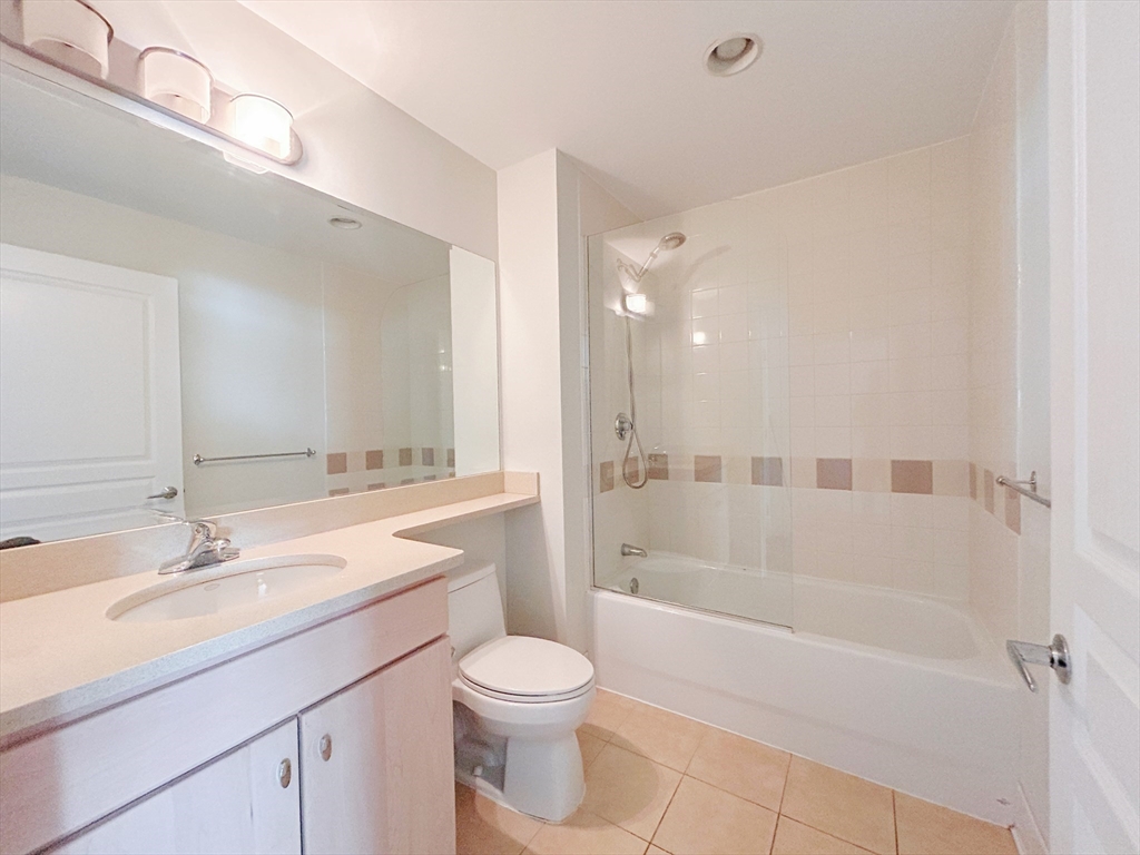 4 Repton Place, Unit 4415 Watertown, MA 02472 - Photo 15 of 25 a bathroom with a bathtub shower sink mirror and toilet