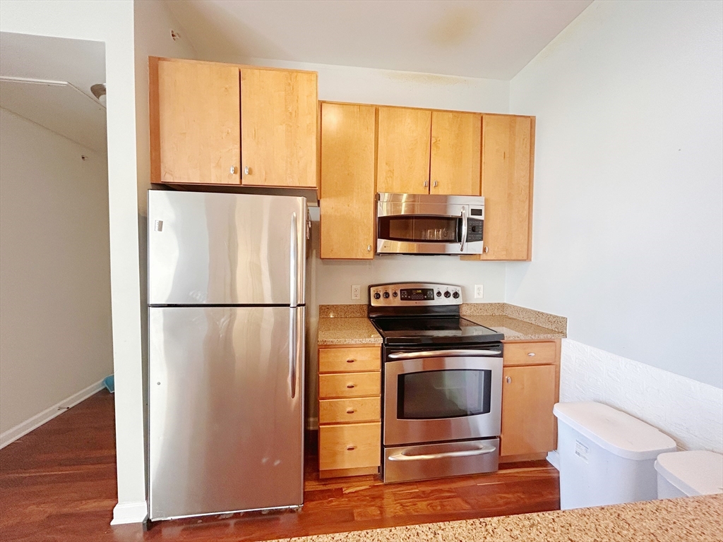 4 Repton Place, Unit 4415 Watertown, MA 02472 - Photo 2 of 25 a kitchen with a stove a refrigerator and a microwave