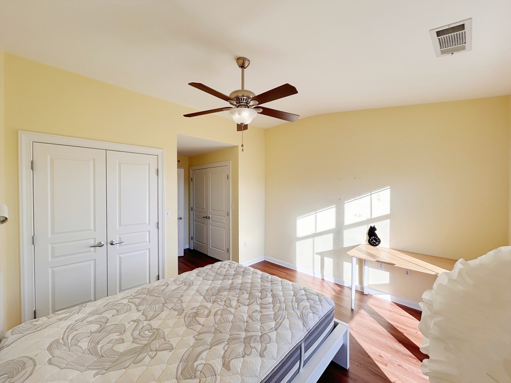 4 Repton Place, Unit 4415 Watertown, MA 02472 - Photo 7 of 25 a bedroom with a bed and a chandelier