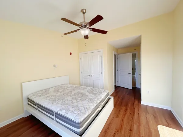 a view of a room with wooden floor and a ceiling fan