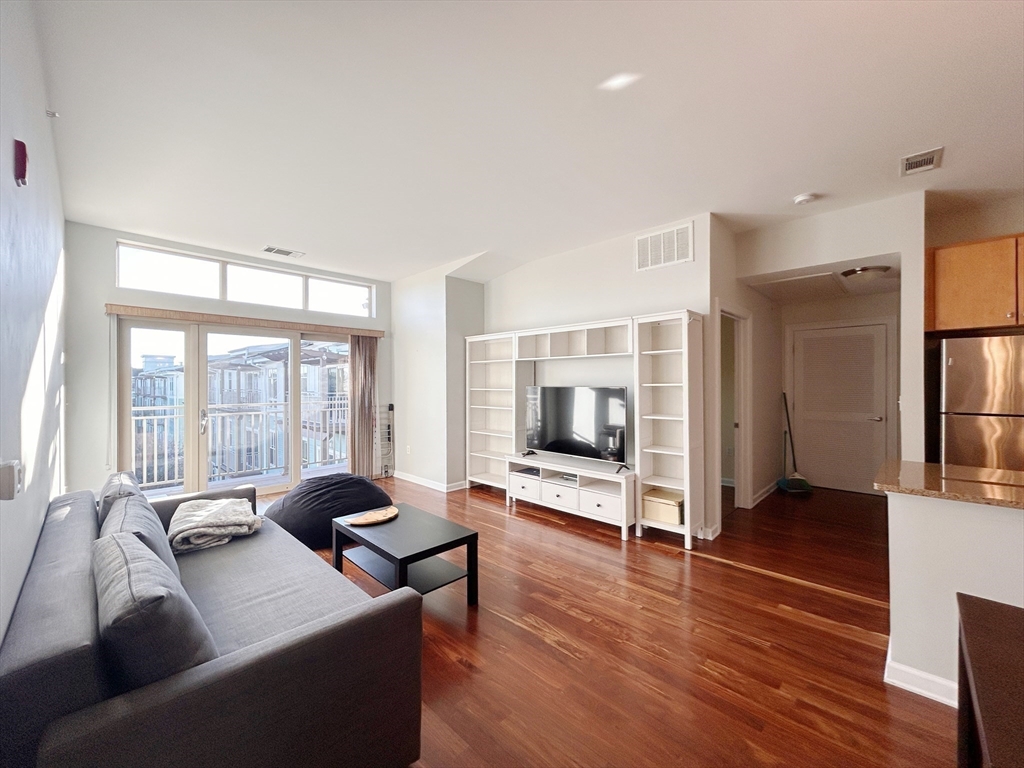 4 Repton Place, Unit 4415 Watertown, MA 02472 - Photo 9 of 25 a living room with furniture a large window and wooden floor