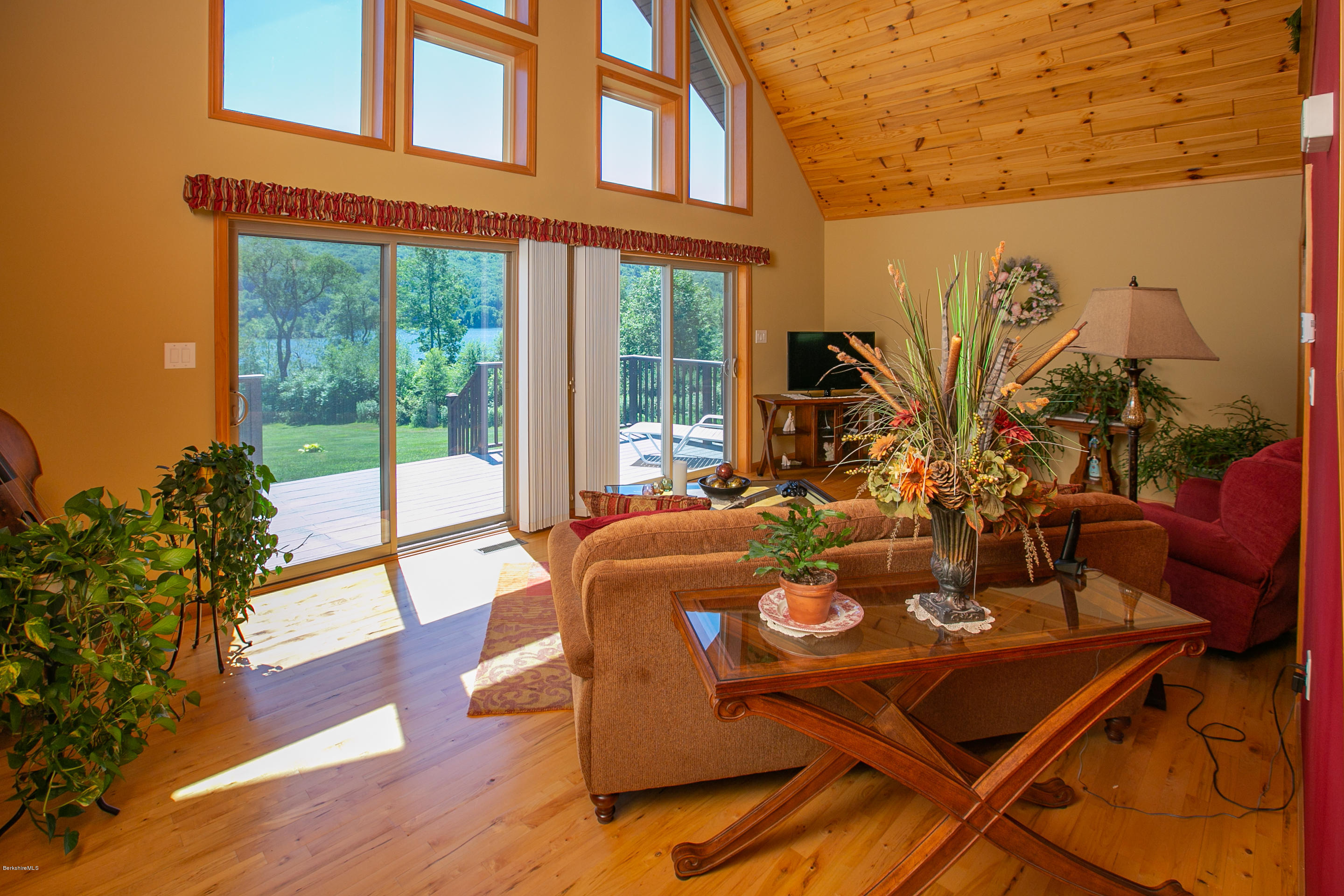 a view of a patio with table and chairs potted plants with wooden floor and fence