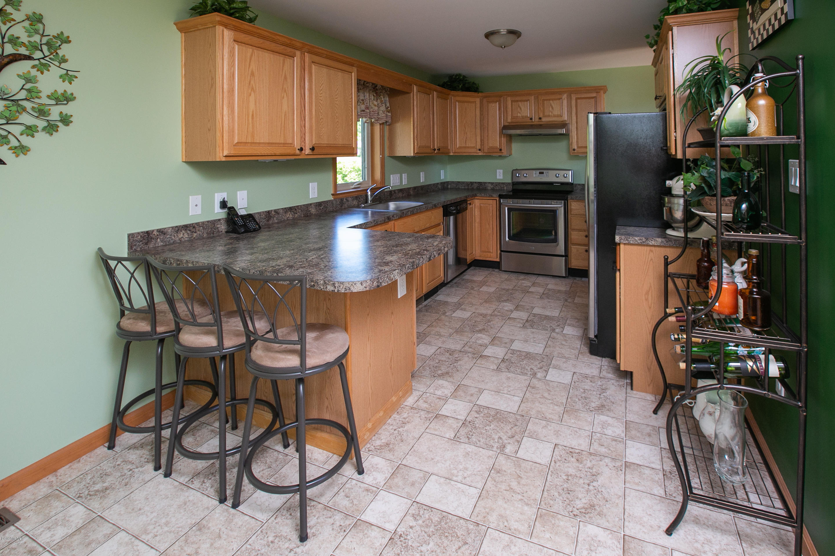 595 Lanesboro Road Cheshire, MA 01225 - Photo 7 of 32 a kitchen with stainless steel appliances kitchen island granite countertop a table chairs in it and a window