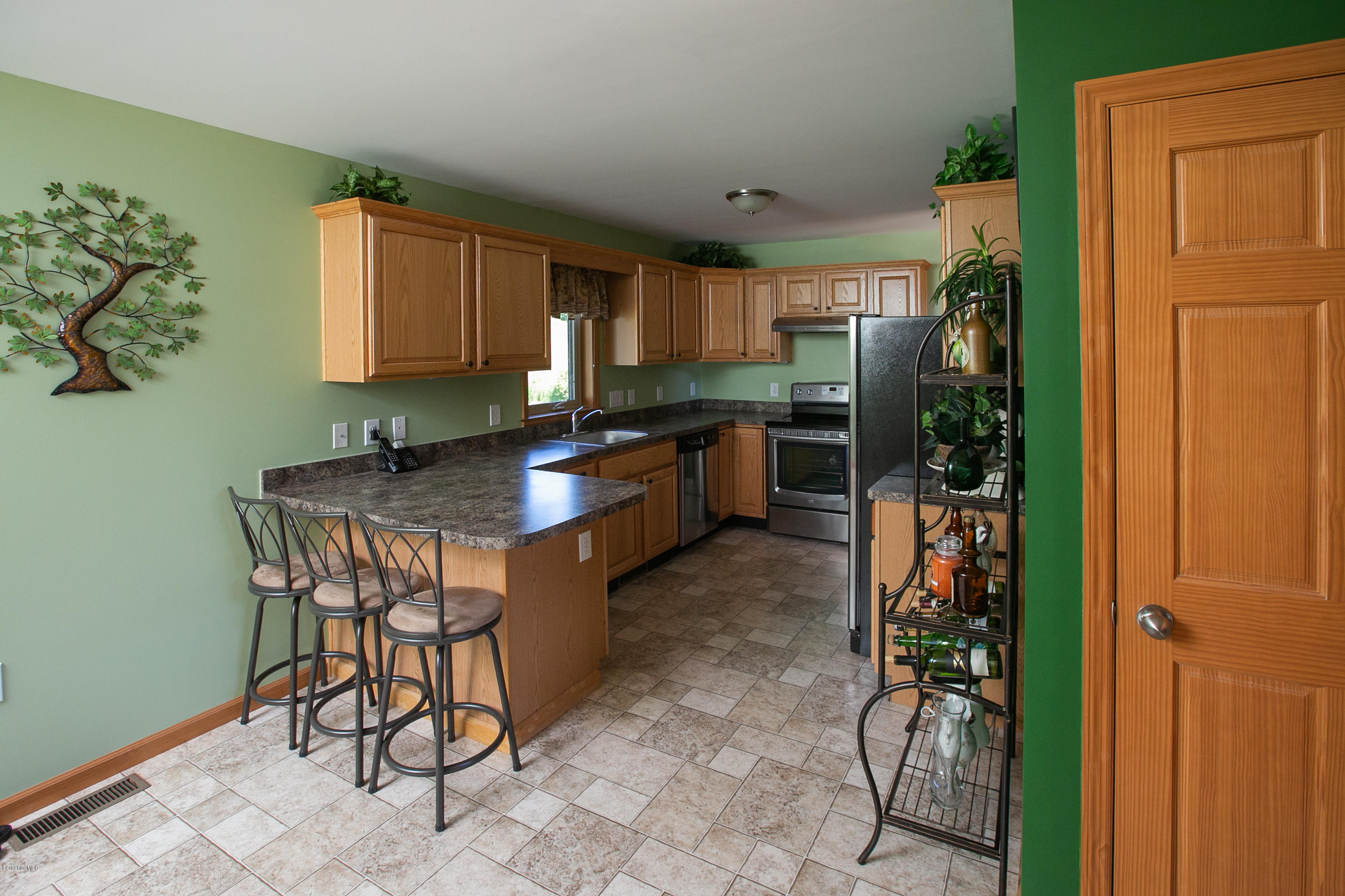 595 Lanesboro Road Cheshire, MA 01225 - Photo 9 of 32 a kitchen with granite countertop a table chairs stove and cabinets