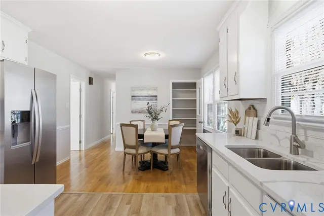 a kitchen with stainless steel appliances sink dining table and chairs