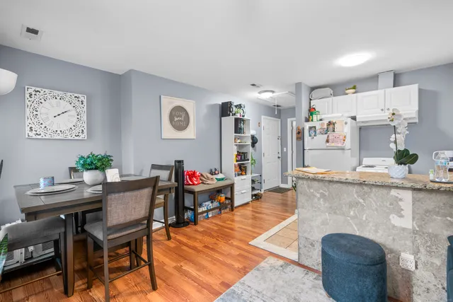 a view of a dining room with furniture wooden floor and a kitchen