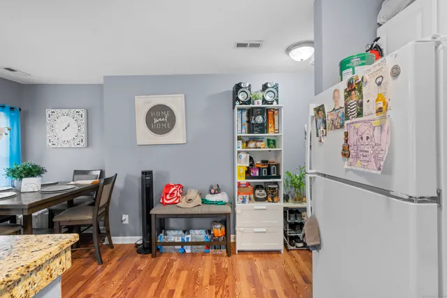 a kitchen with stainless steel appliances granite countertop a refrigerator sink stove and white cabinets