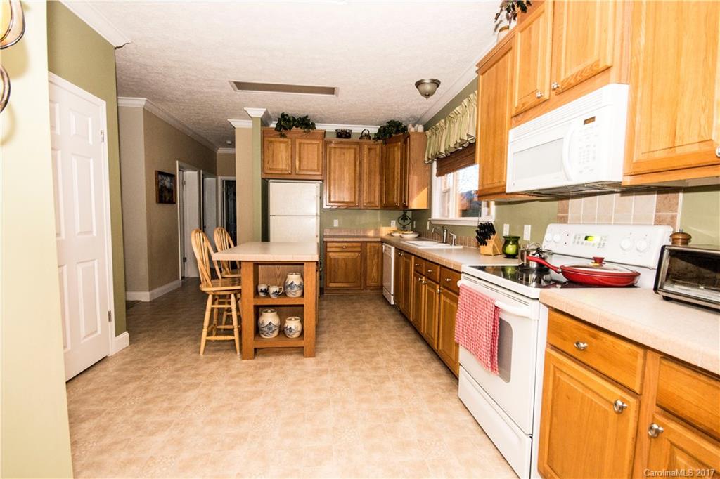 423 Ridgedale Road Clyde, NC 28721 - Photo 9 of 19 a kitchen with a sink stove and chairs