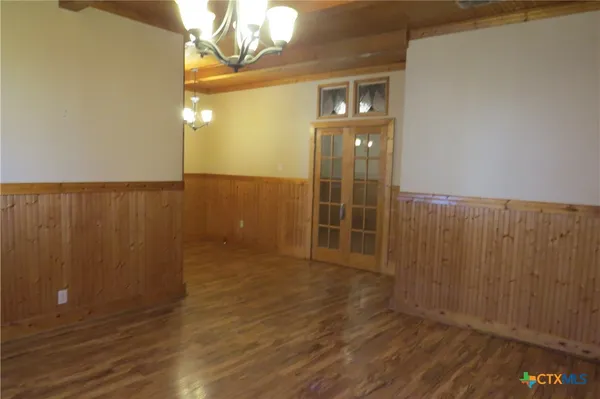 en empty room with wooden floor and fan