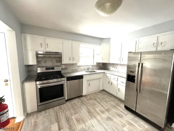 a kitchen with a refrigerator sink and stove top oven