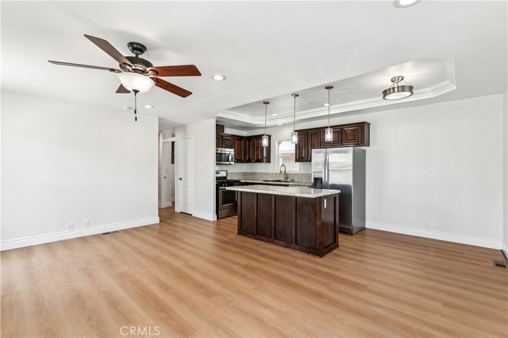 10550 Dunlap Crossing Road, Unit 141 Whittier, CA 90606 - Photo 6 of 38 a kitchen with stainless steel appliances kitchen island wooden cabinets and entryway