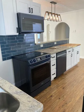 a kitchen with a sink a refrigerator and wooden floor