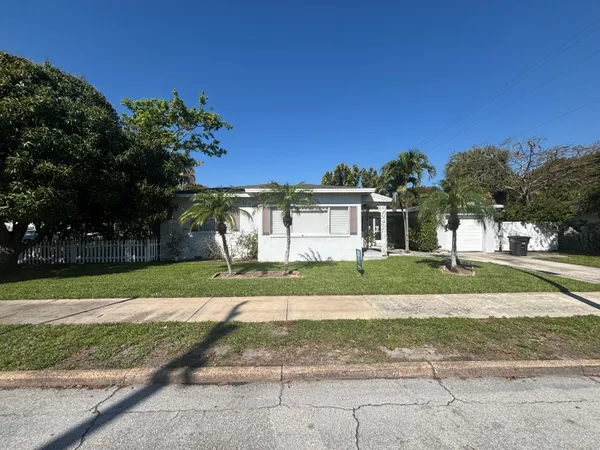 a front view of a house with a yard and trees