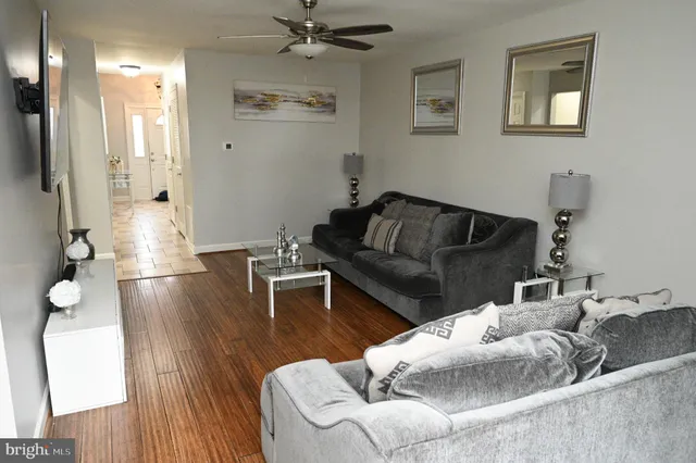 a living room with furniture and a wooden floor