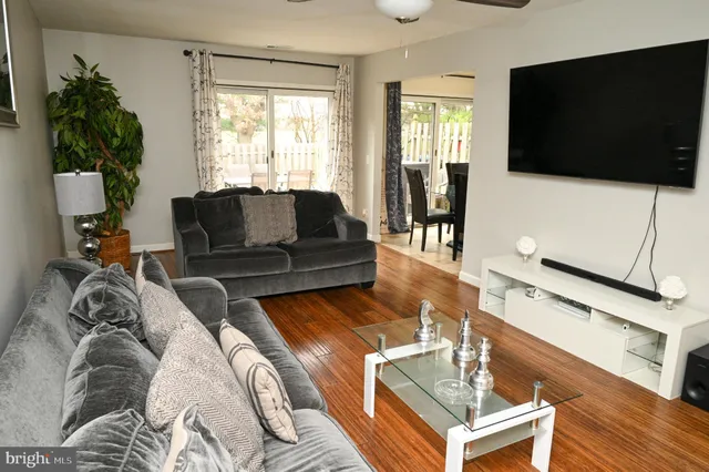 a living room with furniture a flat screen tv and a window