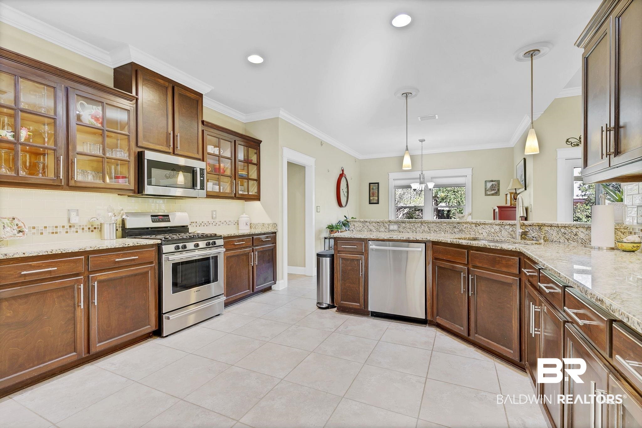 20105 Bunker Loop Fairhope, AL 36532 - Photo 5 of 65 Kitchen with light granite counters, light tile patterned floors, ornamental molding, stainless steel appliances, and tile backsplash