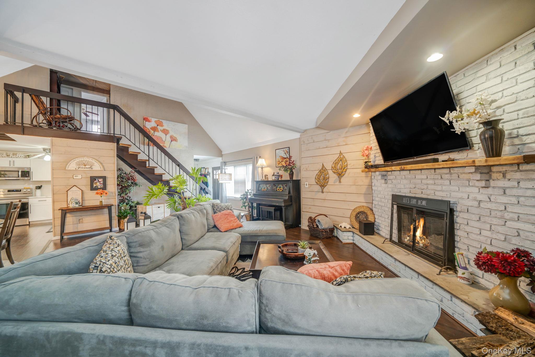 6 Howe Court Coram, NY 11727 - Photo 4 of 17 a living room with furniture a flat screen tv and a fireplace