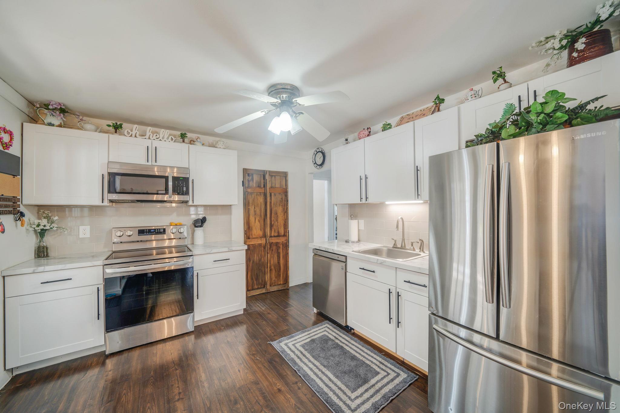 6 Howe Court Coram, NY 11727 - Photo 8 of 17 a kitchen with stainless steel appliances a refrigerator sink and microwave