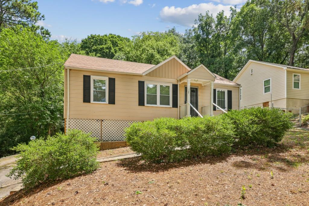a front view of a house with a yard and trees