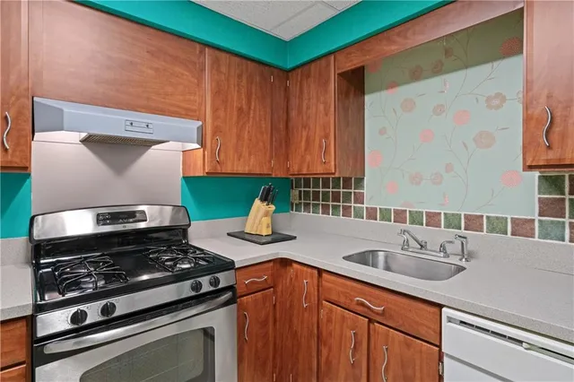 a kitchen with a sink stove and cabinets