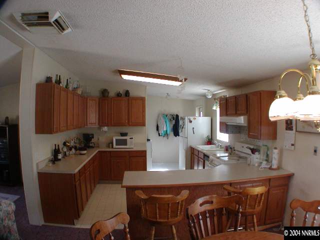 15205 Westwind Circle Reno, NV 89521 - Photo 6 of 6 a kitchen with a table chairs stove and cabinets