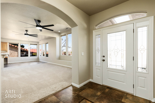 2158 Balboa Way St. George, UT 84770 - Photo 4 of 40 Entryway with a ceiling fan, arched walkways, dark colored carpet, and a textured ceiling