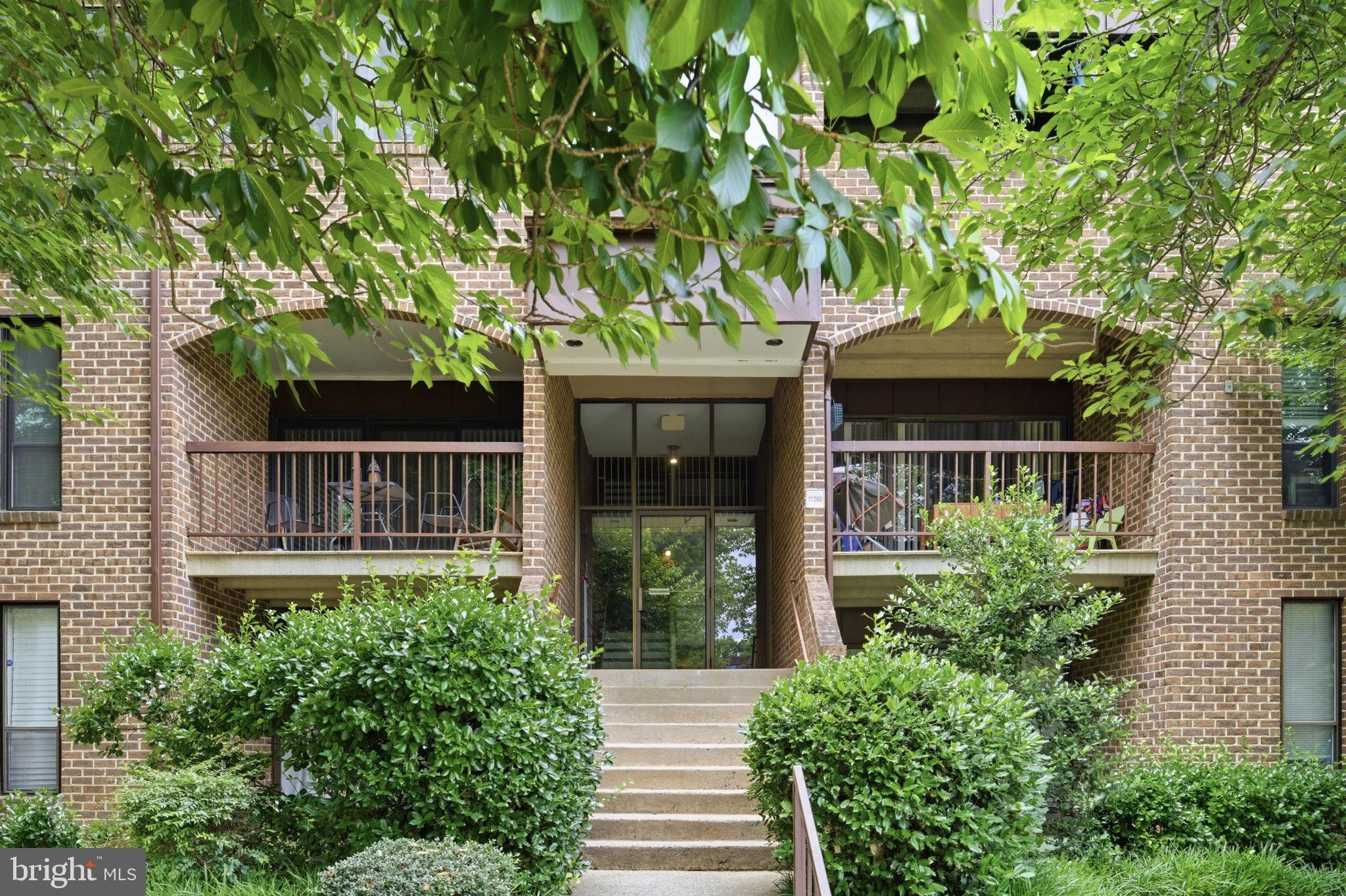 11260 Chestnut Grove Square, Unit 337 Reston, VA 20190 - Photo 57 of 82 Charming brick facade with lush greenery.