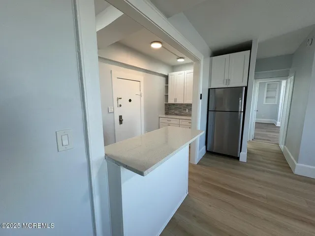 a kitchen with a refrigerator a sink and wooden floor