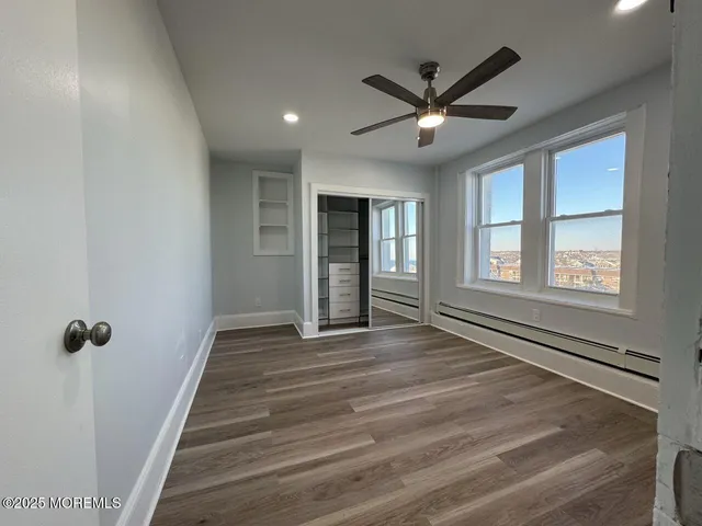 a view of a livingroom with a ceiling fan and wooden floor