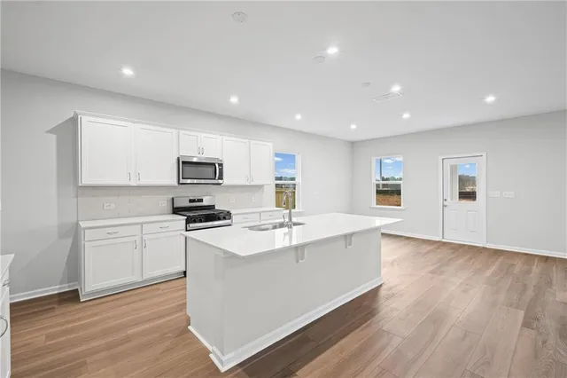 a kitchen with a sink stainless steel appliances and white cabinets